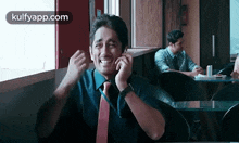 a man is laughing while talking on a cell phone