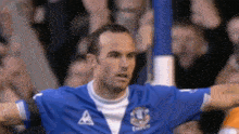 a soccer player wearing a blue jersey with the letter a on the front