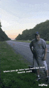a man standing on the side of a highway with the caption when you go into taco bell for that fourth refill on the bottom