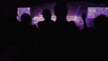 a woman is singing into a microphone with her hand in the air
