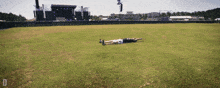 a person laying on their back in a field with the letter d on the bottom left
