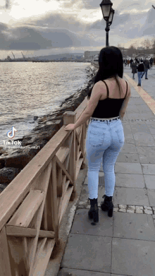 a woman leaning against a railing with a tiktok watermark