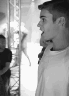 a black and white photo of a man with his mouth wide open