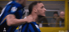 a man in a blue jersey with the number 9 on it is being hugged by another man