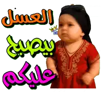 a baby in a red dress with arabic writing behind him
