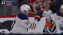 a hockey player with the number 90 on his jersey is being congratulated by another player