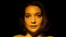 a woman is making a funny face in a dark room .