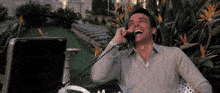 a man laughs while talking on a phone outside