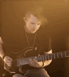 a man playing a guitar with the letter k on the neck