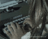 a woman is typing on a brabant in beelden.nl typewriter