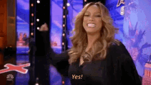 a woman is standing on a stage giving a thumbs up and saying yes .