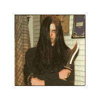 a man with long black hair is holding a knife in his hands