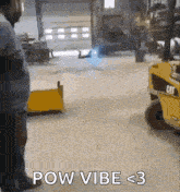 a man is standing in front of a forklift that says pow vibe < 3 on it .