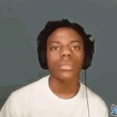 a young man wearing headphones is looking at the camera .
