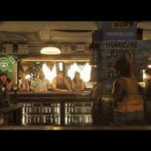 a group of people sitting at a bar with a sign that says hurricane roxy