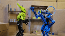 two lego robots are standing next to each other in a room