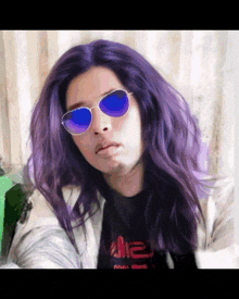 a woman with purple hair wearing sunglasses and a t-shirt that says ' me ' on it