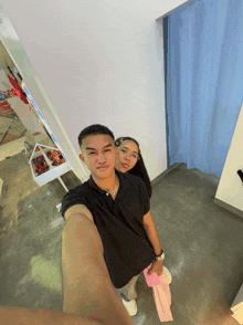 a man and a woman pose for a selfie in a room