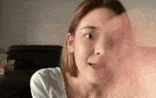 a close up of a woman 's face while looking at something in a mirror .