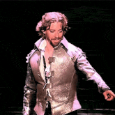 a man with a beard is wearing a silver jacket