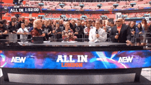 a group of people standing behind a desk that says all in london on it