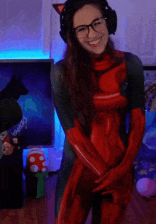 a woman in a red latex suit and gloves smiles