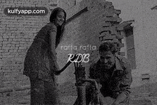 a man and a woman are standing next to each other in front of a brick building .