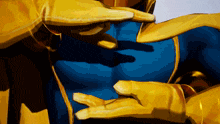 a close up of a person 's chest with a blue shirt and yellow gloves