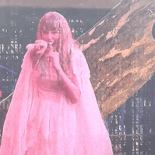 a woman in a pink dress with wings on her arms