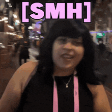 a woman wearing a black top and a pink lanyard says [ smh ] in pink letters
