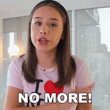 a girl is wearing a pink shirt that says i love ny and says no more .