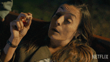 a woman smoking a cigarette with a netflix logo in the background