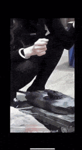a person kneeling down with their hands on a box that says bn on it
