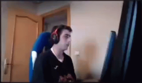 A gif showing a man smashing his keyboard with his fist. In anger, he causes his second monitor to topple and keys to fly out of the keyboard.