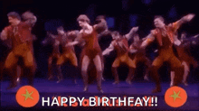 a group of people are dancing on a stage with the words `` happy birthday '' written above them .