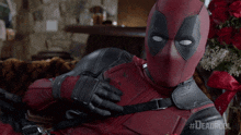 a man in a deadpool costume is laying down on a couch