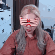 a woman with red nails is wearing a pair of glasses