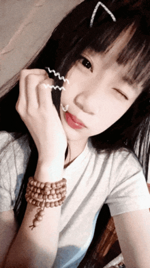 a girl with a cat ear clip on her hair looks at the camera