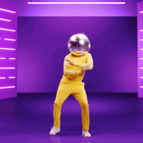 A man in a yellow suit and a disco-ball-helmet dancing 