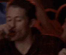 a man is drinking from a shot glass with his mouth open