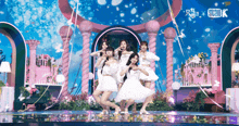 a group of girls are dancing on a stage with studio k written on the bottom right