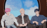 three anime characters sitting in front of a window with a blue sky in the background