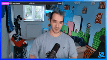 a man with blue hair is standing in front of a microphone