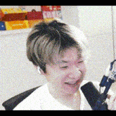 a man is sitting in front of a microphone and smiling while wearing headphones .
