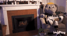 an elephant mascot is sitting in a chair in front of a fireplace with the hashtag imgplay at the bottom