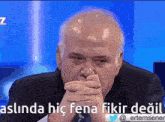 a man covering his mouth with his hands with the words aslinda hic fena fikir degil written below him