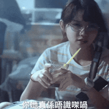 a woman wearing glasses holds a glass with a straw