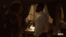 a man and a woman are hugging in a dark room with a bet logo on the wall