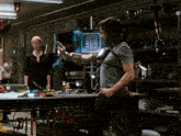 a man in a gray shirt is standing in front of a woman in a black shirt