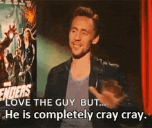 a man is standing in front of a sign that says `` enders love the guy but ... he is completely cray cray . ''